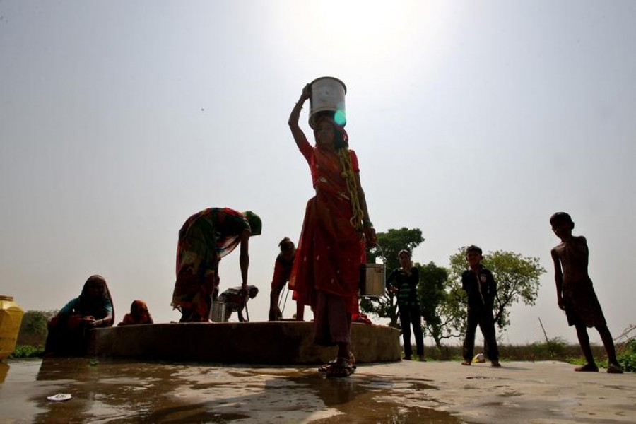 People fetch water from a pit at an abandoned stone quarry on a hot day in Badama village in the northern state of Uttar Pradesh, India, May 4, 2022. REUTERS/Ritesh Shukla