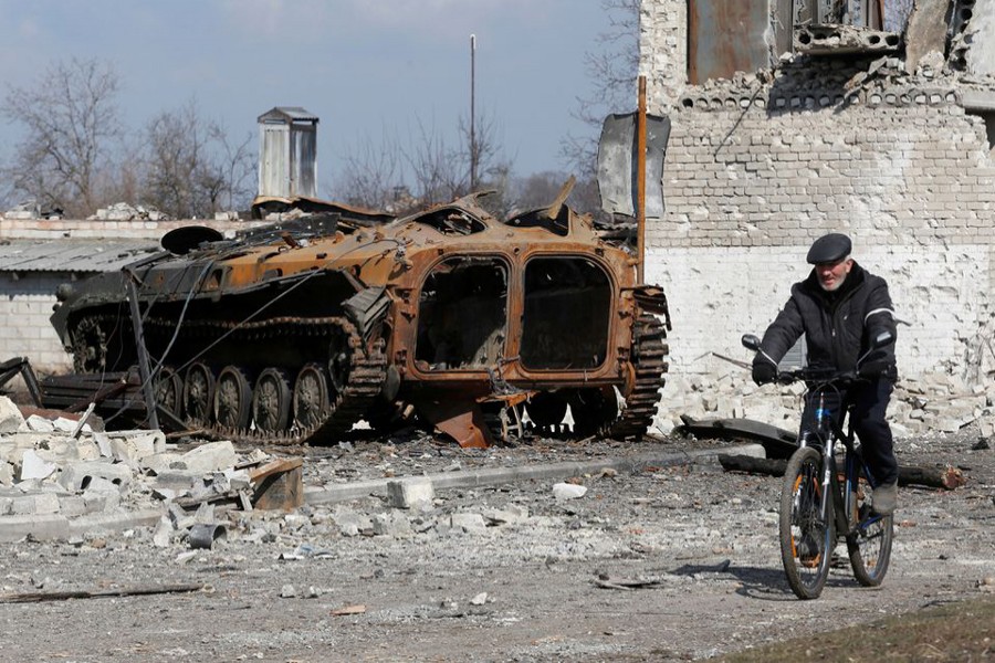 A local resident rides a bicycle past a charred armoured vehicle during Ukraine-Russia conflict in the separatist-controlled town of Volnovakha in the Donetsk region, Ukraine on March 15, 2022 — Reuters/Files