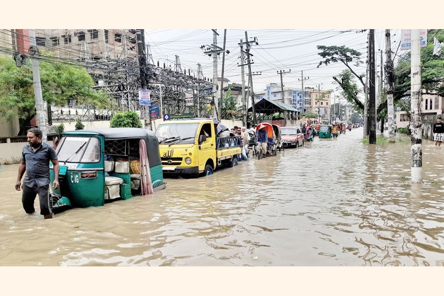 Vehicles striving to move on a waterlogged road in Shahjalal Uposhahar area of Sylhet city on Tuesday — Focus Bangla
