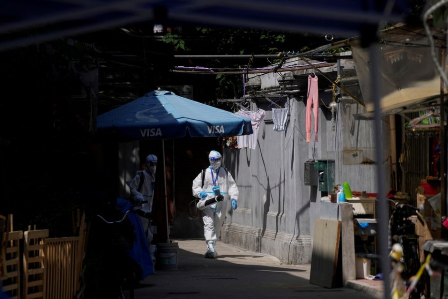 Workers in protective suits disinfect a closed residential area during lockdown, amid the coronavirus disease (COVID-19) outbreak, in Shanghai, China, May 18, 2022. REUTERS/Aly Song