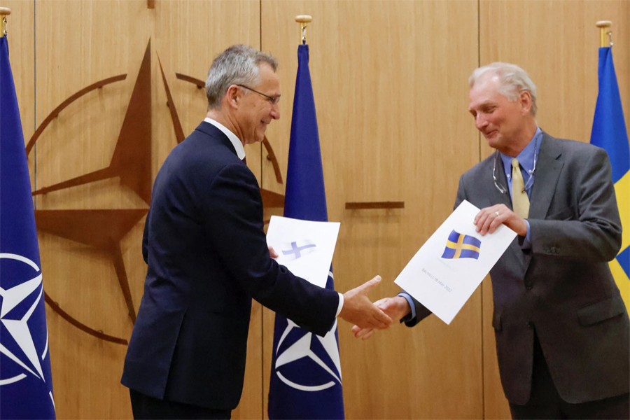 NATO Secretary-General Jens Stoltenberg and Sweden's Ambassador to NATO Axel Wernhoff shake hands during a ceremony to mark Sweden's and Finland's application for membership in Brussels, Belgium on May 18, 2022 — Pool via Reuters