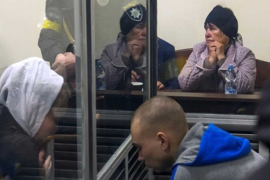 A representative of a victim Kateryna Shelikhova sits next to a Russian soldier Vadim Shishimarin, 21, suspected of violations of the laws and norms of war, during a court hearing, amid Russia's invasion of Ukraine, in Kyiv, Ukraine May 18, 2022. REUTERS/Vladyslav Musiienko