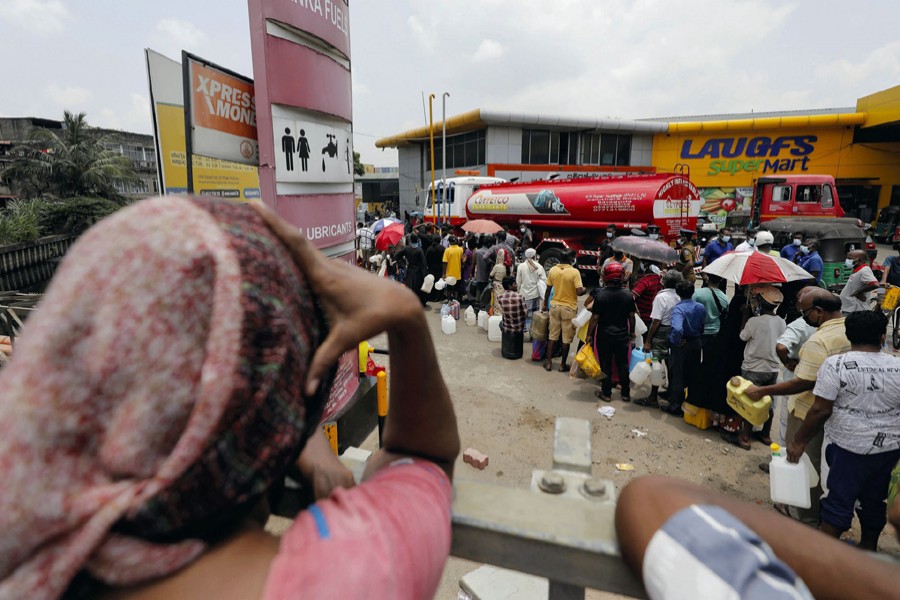People stand in a long queue to buy kerosene oil for kerosene cookers amid a shortage of domestic gas due to country's economic crisis, at a fuel station in Colombo, Sri Lanka on March 21, 2022 — Reuters/Files