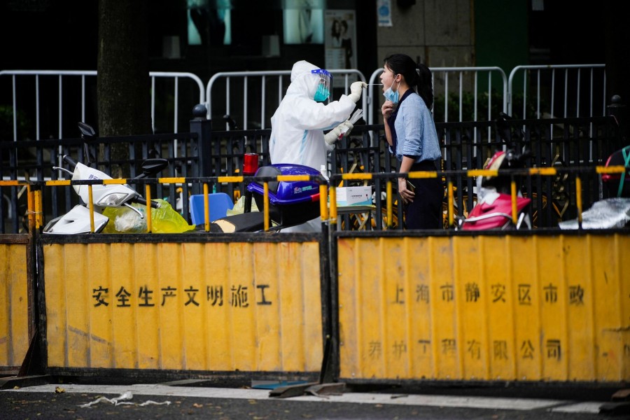 A medical worker collects a swab sample from a woman at a nucleic acid testing site on a street during lockdown, amid the coronavirus disease (Covid-19) pandemic, in Shanghai, China on May 20, 2022 — Reuters photo