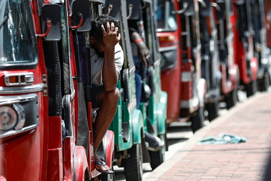 A man waits inside a three-wheeler near a line to buy petrol from a fuel station, amid the country's economic crisis, in Colombo, Sri Lanka on May 23, 2022 — Reuters photo