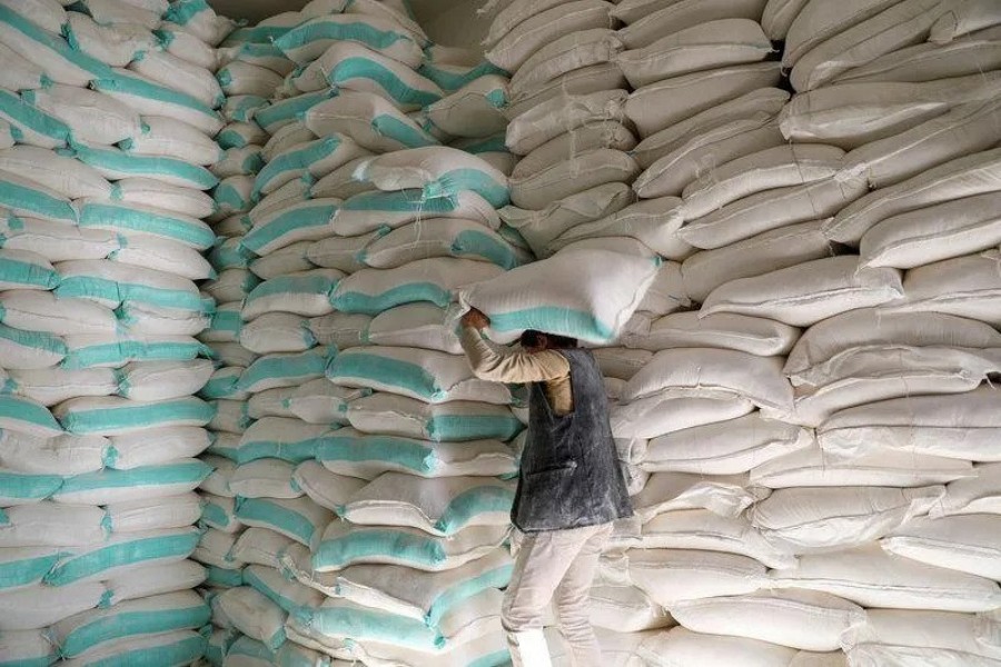 FILE PHOTO: A worker carries a sack of wheat flour at a World Food Programme food aid distribution center in Sanaa - Reuters