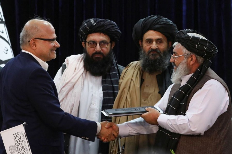 Razack Aslam Mohammed Abdur Razack, United Arab Emirates (UAE) chief financial officer of GAAC firm, and Ghulam Jilani Wafa, Deputy Ministry of Transport and Taliban's Deputy Head of Civil Aviation of Afghanistan, exchange documents during the signing ceremony in Kabul, Afghanistan, May 24, 2022. REUTERS/Ali Khara