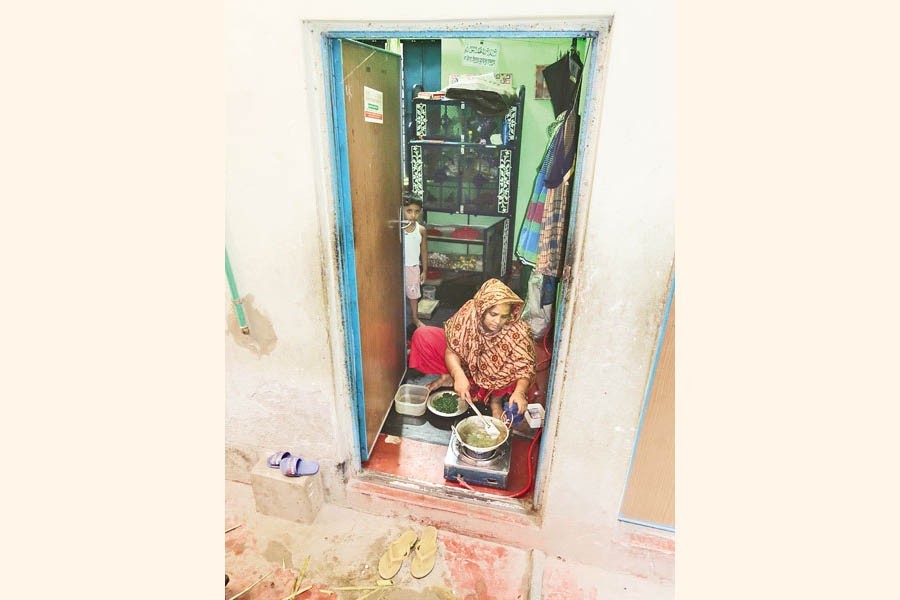 This woman is cooking using a liquefied natural gas (LNG) cylinder at a house in Dhaka's Kamrangirchar on Wednesday. Thousands of people living there are struggling after the state-run Titas Gas Transmission and Distribution Company Limited cut off the supply around a month ago for 'unpaid bills' and for allegedly using illegal gas connections — FE photo