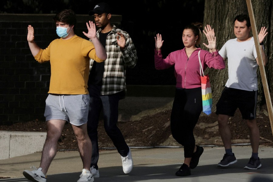 Local residents hold their hands in the air as they are evacuated to safety by police at the scene of a reported shooting and active shooter near Edmund Burke Middle School in the Cleveland Park neighborhood of Northwest Washington, US on April 22, 2022 — Reuters photo