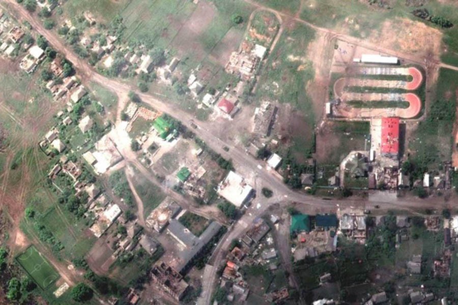 A satellite image shows damaged buildings and a tank on a road, in Lyman, Ukraine May 25, 2022. Satellite image 2022 Maxar Technologies/Handout via Reuters