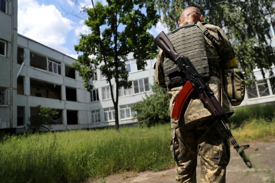 A member of the Ukrainian Territorial Defense Forces prepares to use a drone at a damaged school after a missile strike, amid Russia's attack on Ukraine, at a residential area in Kharkiv, Ukraine Jun 2, 2022. REUTERS