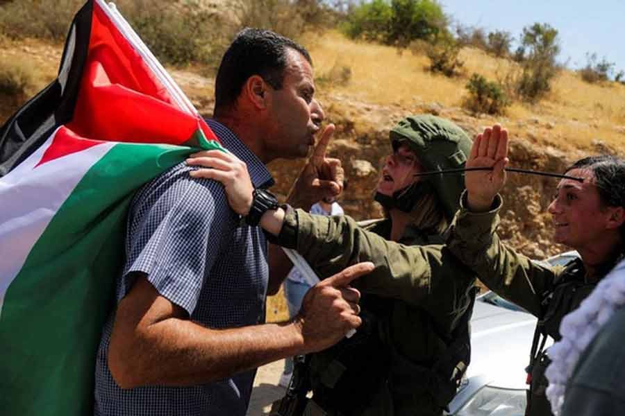 Israeli soldiers arguing with a demonstrator holding a Palestinian flag during a protest against Israeli settlements in Jordan Valley in the Israeli-occupied West Bank on Monday –Reuters photo