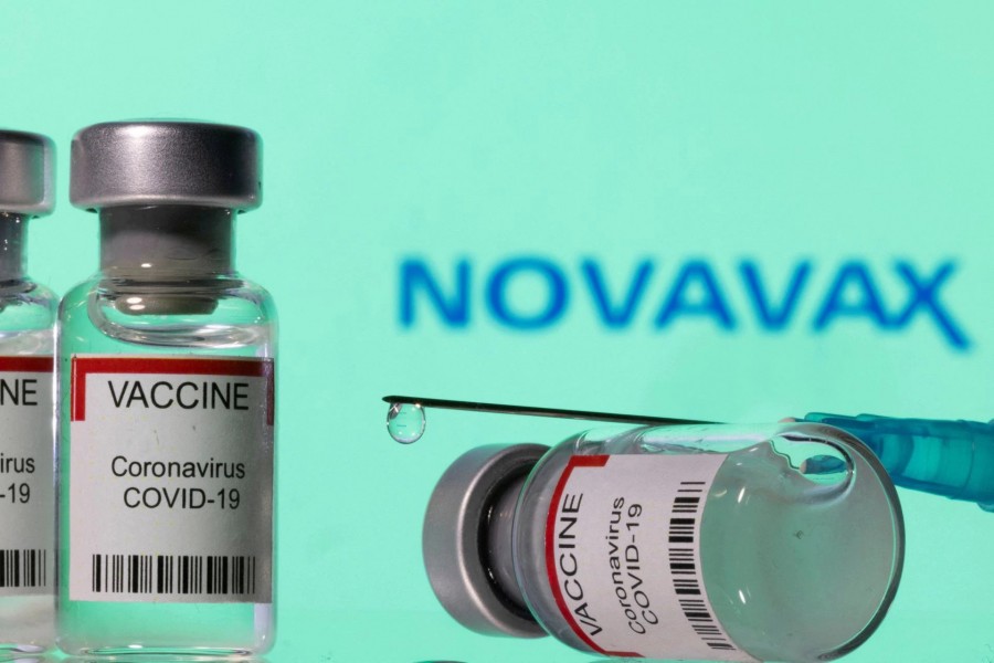 Vials labelled "VACCINE Coronavirus COVID-19" and a syringe are seen in front of a displayed Novavax logo in this illustration taken December 11, 2021. REUTERS/Dado Ruvic/Illustration