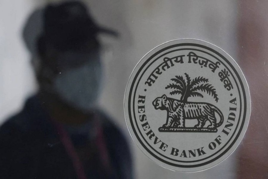 A man walks behind the Reserve Bank of India (RBI) logo inside its headquarters in Mumbai, India, April 8, 2022. REUTERS/Francis Mascarenhas