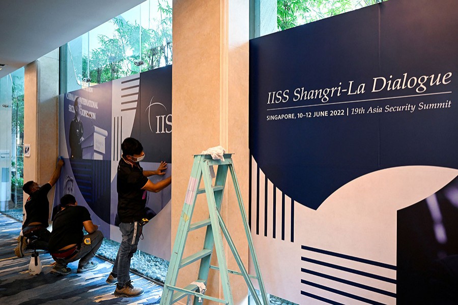 Workers put up banners in preparation for the 19th IISS Shangri-La Dialogue 2022 taking place from 10-12 June in Singapore on June 9, 2022 — Reuters photo