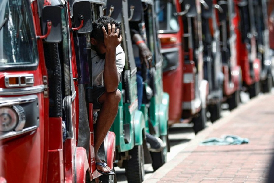 A man waits inside a three-wheeler near a line to buy petrol from a fuel station, amid the country's economic crisis, in Colombo, Sri Lanka, May 23, 2022. REUTERS/Dinuka Liyanawatte
