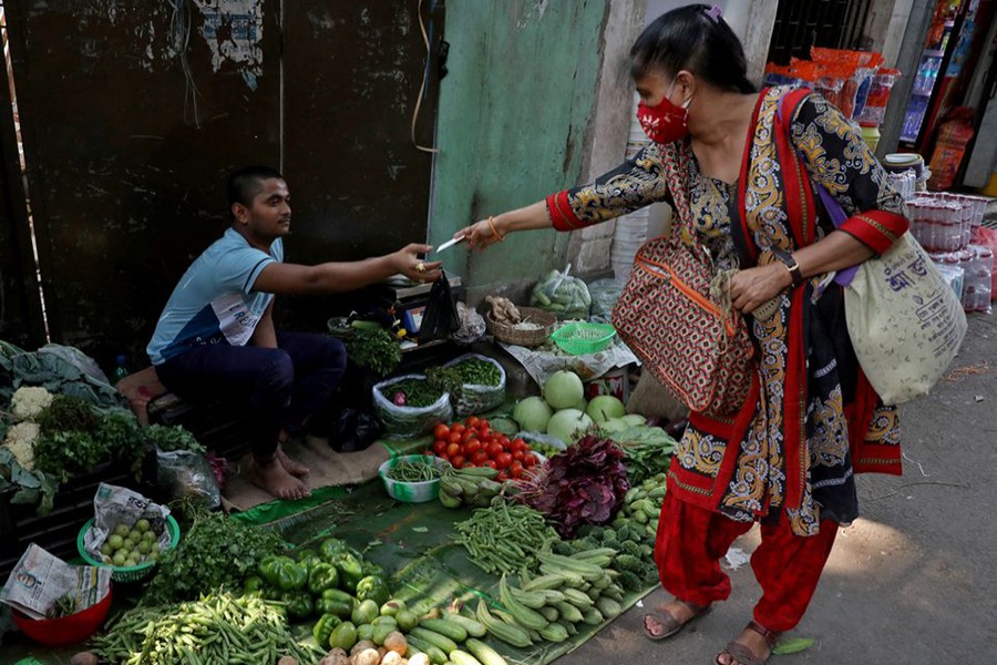 Indrani Majumder, a consumer, buys vegetables from a roadside vegetable vendor in Kolkata, India on March 22, 2022 — Reuters/Files