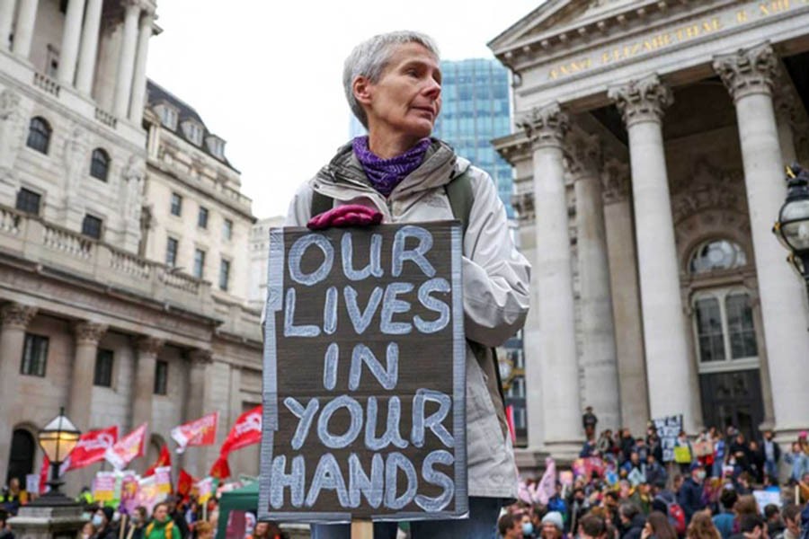 A demonstrator holds a banner during a protest outside the Bank of England, as the UN Climate Change Conference (COP26) takes place, in London, Britain, November 6, 2021. Reuters
