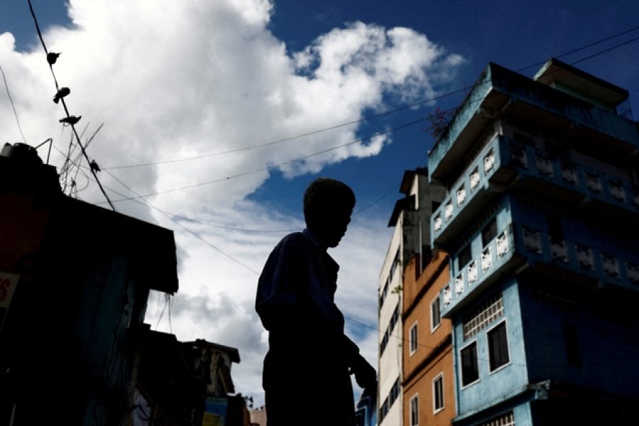 FILE PHOTO: A worker stands in front of a closed essential food store during a nationwide strike in Colombo, Sri Lanka, Apr 28, 2022. Reuters