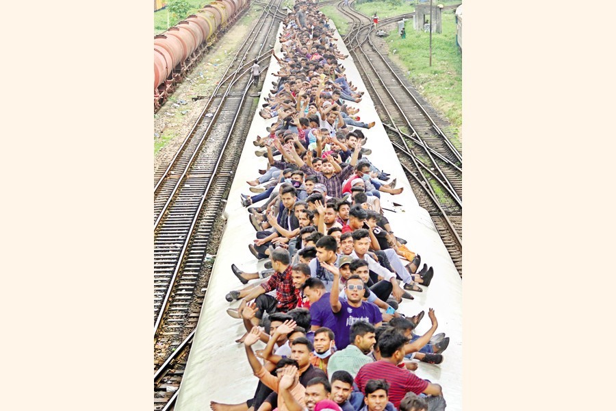 Defying risks, holidaymakers ride on the rooftop of a train to go to their village homes to celebrate Eid-ul-Azha with their near and dear ones. The photo was taken at Kamalapur Railway Station in Dhaka on Friday — FE photo