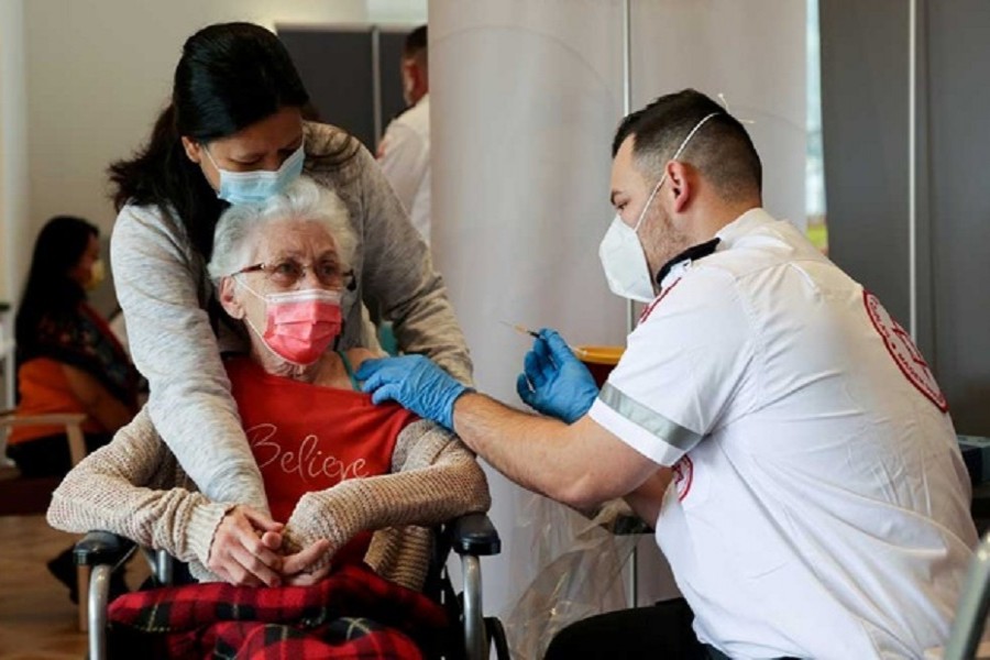 An elderly woman receives a booster shot of her vaccination against the COVID-19 at an assisted living facility, in Netanya, Israel January 19, 2021. REUTERS
