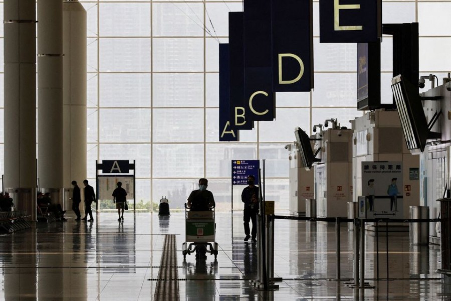 A traveller walks in the departure hall at the Hong Kong International Airport amid the coronavirus disease (COVID-19) pandemic in Hong Kong, China, March 21, 2022. REUTERS/Tyrone Siu/File Photo
