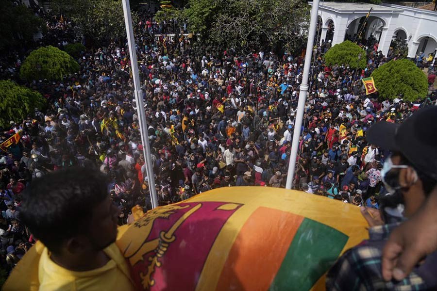 Sri Lankan protesters waving Sri Lankan flag after entering the compound of Prime Minister Ranil Wickremesinghe's office in Colombo on Wednesday amid the economic crisis in Sri Lanka –AP Photo