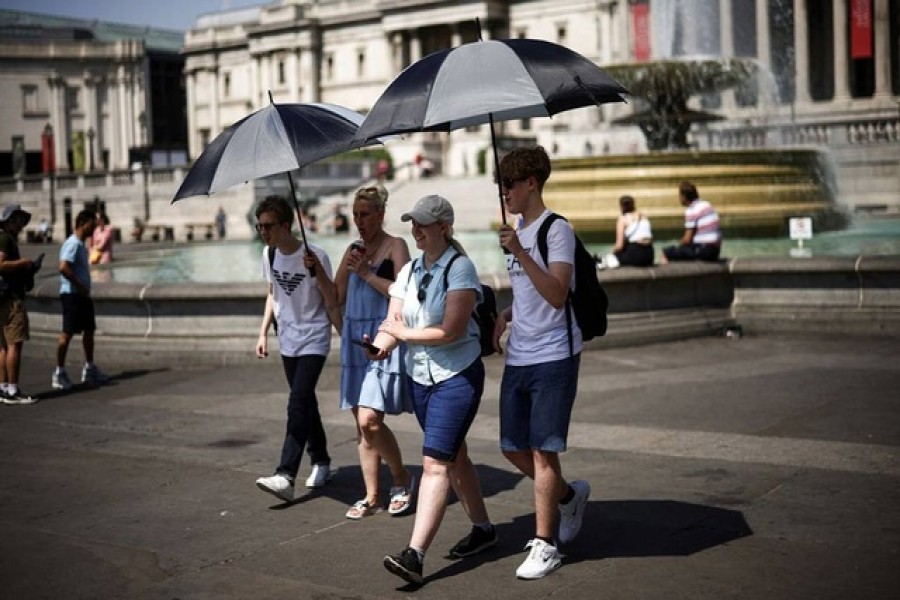 People carry umbrellas to hide in their shadow during a heatwave, at Trafalgar Square in London, Britain, July 19, 2022. Reuters