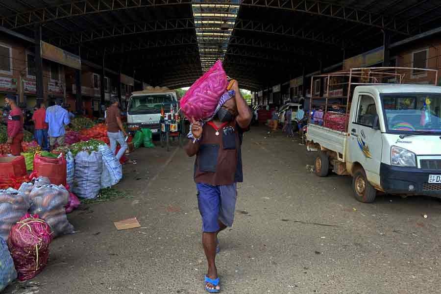 A worker carrying a sack of vegetables towards a truck at Dambulla in Sri Lanka on February 15 this year –Reuters file photo