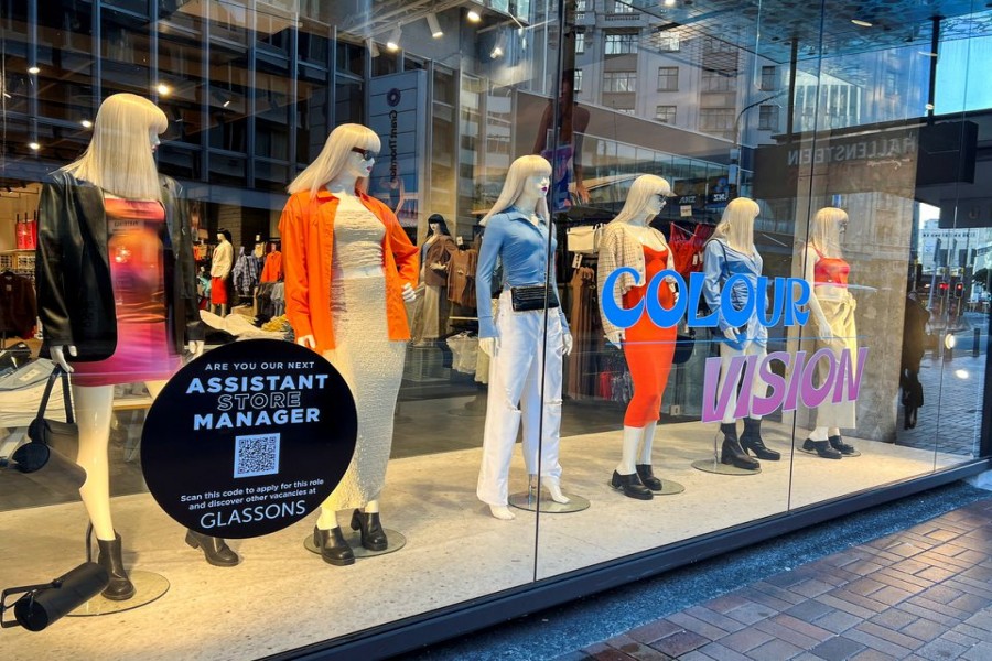 A sign advertising staff requirement is displayed on a store window at Lambton Quay, as the country experiences near record low unemployment, in Wellington, New Zealand August 3, 2022. REUTERS/Lucy Crayme