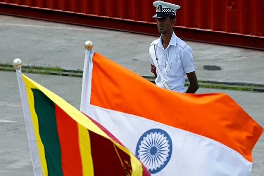 A Navy officer stands in front of India's and Sri Lanka's national flags as Indian Coast Guard Ship (ICGS) Shoor is in the Colombo port during its visit to Colombo, Sri Lanka Apr 2, 2018. REUTERS