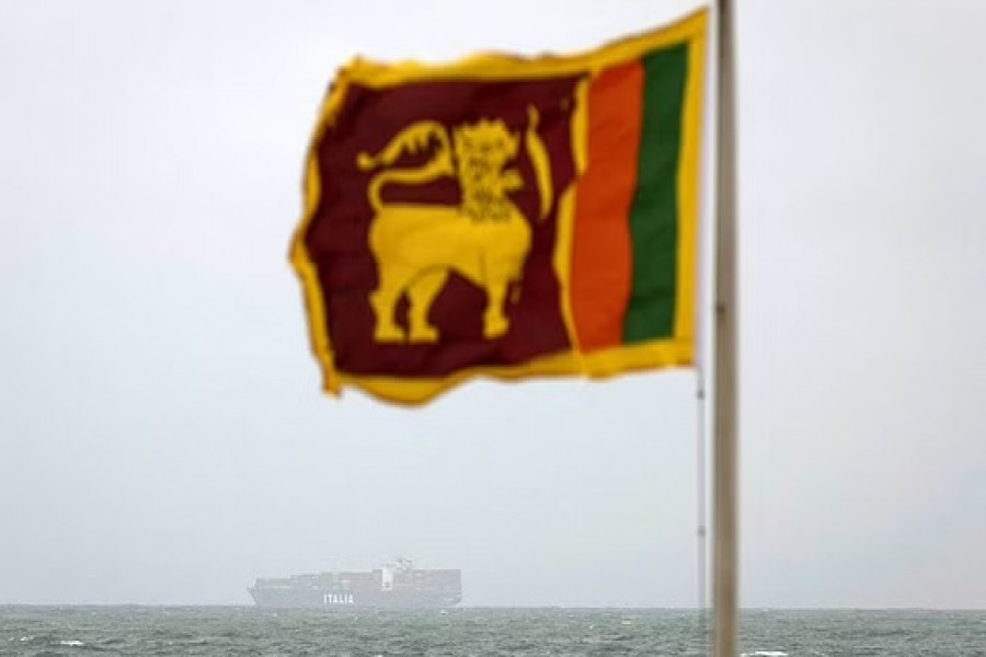 A cargo ship sails towards Colombo Harbour as a Sri Lankan national flag is seen, amid the country's economic crisis in Colombo, Sri Lanka, July 23, 2022. REUTERS/Adnan Abidi