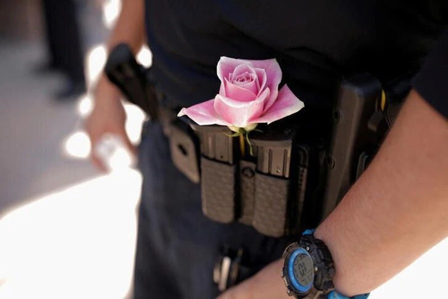 An officer from the Albuquerque Police Department wears a rose next to his gun magazines during a unity event against anti-Shia hate following the murders of four Muslim men in Albuquerque, New Mexico, US on August 12, 2022 — Reuters photo
