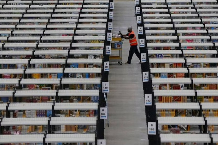 A worker collects orders at Amazon's fulfilment centre in Rugeley, central England December 11, 2012. REUTERS/Phil Noble