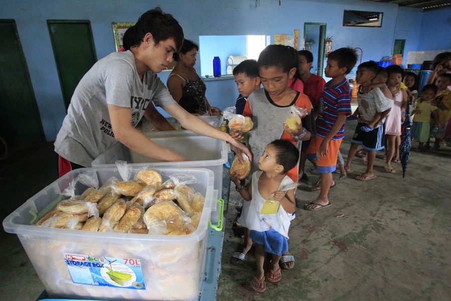 Children queue for a free meal during a feeding program by outreach group World Mission Community Care, at a slum area in the Baseco compound, metro Manila July 30, 2014. REUTERS/Romeo Ranoco