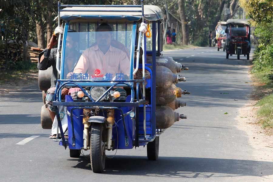 Battery-run rickshaw drivers block road in Demra to protest police action