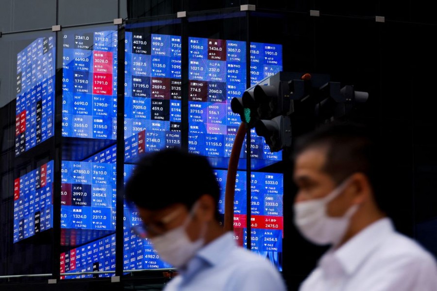 People pass by an electronic screen showing Japan's Nikkei share price index inside a conference hall in Tokyo, Japan June 14, 2022. REUTERS/Issei Kato/File Photo