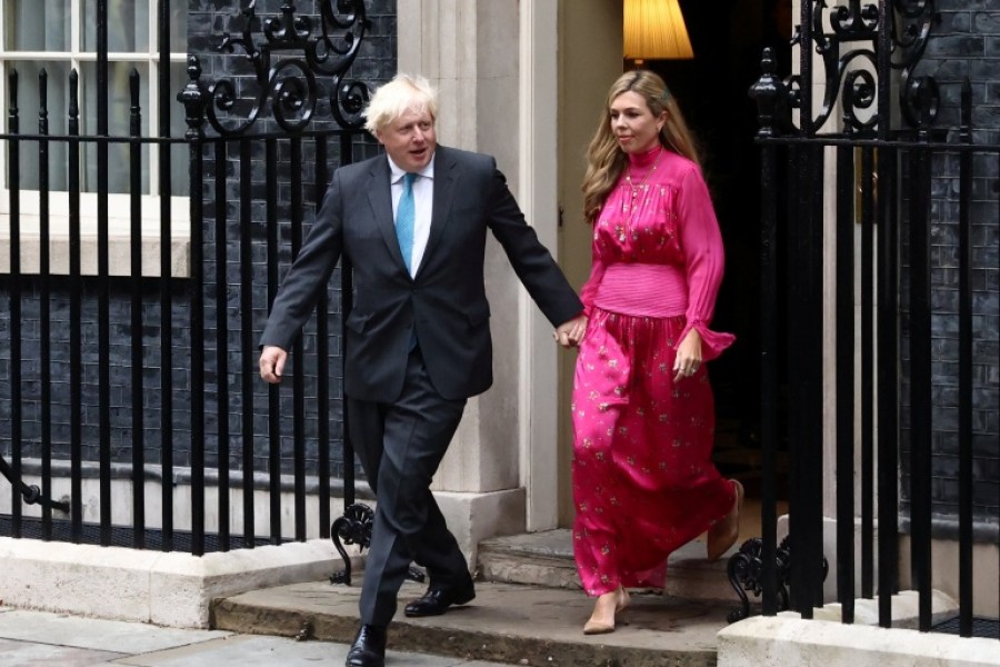 Johnson, with his wife Carrie Johnson, exits his Downing Street office to deliver a speech [Henry Nicholls/Reuters]