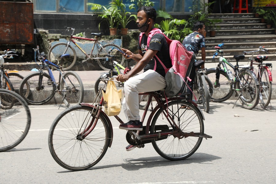 A delivery man in Dhaka is carrying parcels	—FE Photo