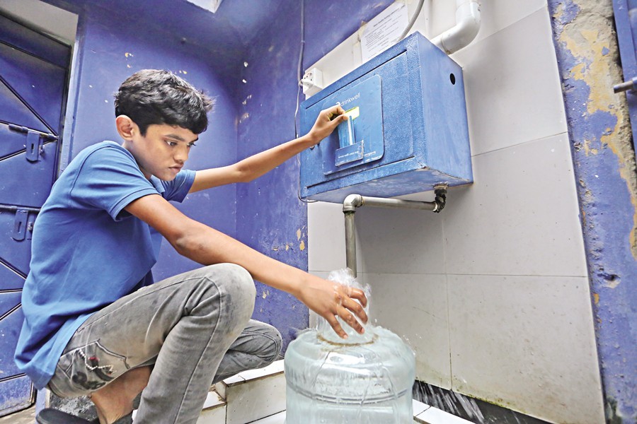 A boy collecting water from a Water ATM Booth of Wasa at Shantibagh in the capital on Friday — FE photo