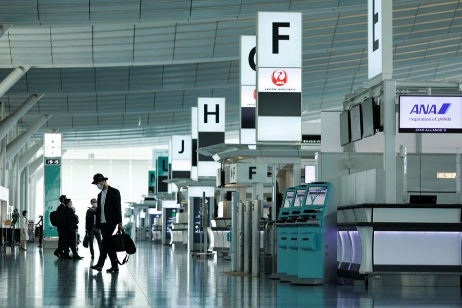 Passengers wearing protective face masks, amid the coronavirus disease (Covid-19) pandemic, walk at the Haneda airport, in Tokyo, Japan on June 13, 2021 — Reuters/Files