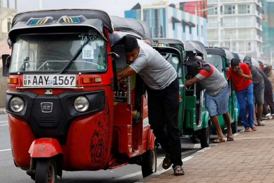 Drivers push auto rickshaws in a line to buy petrol from a fuel station, amid Sri Lanka's economic crisis, in Colombo, Sri Lanka, July 29, 2022. REUTERS/Kim Kyung-Hoon