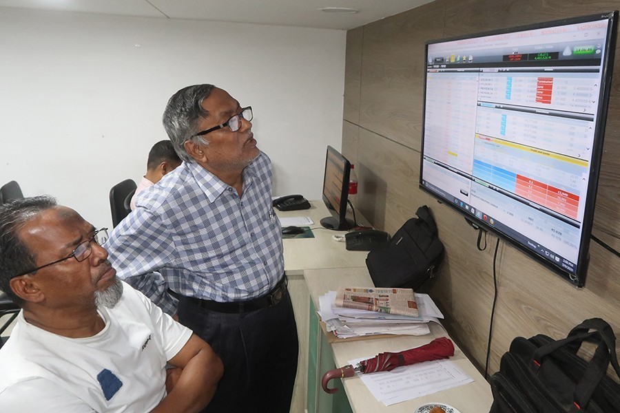 Investors react while monitoring stock price movements on computer and TV screens at a brokerage house in the capital city — FE/Files