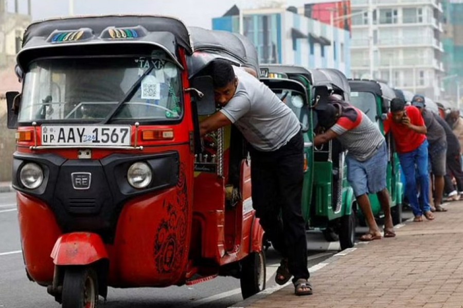 Drivers push auto rickshaws in a line to buy petrol from a fuel station, amid Sri Lanka's economic crisis, in Colombo, Sri Lanka, July 29, 2022. REUTERS/Kim Kyung-Hoon