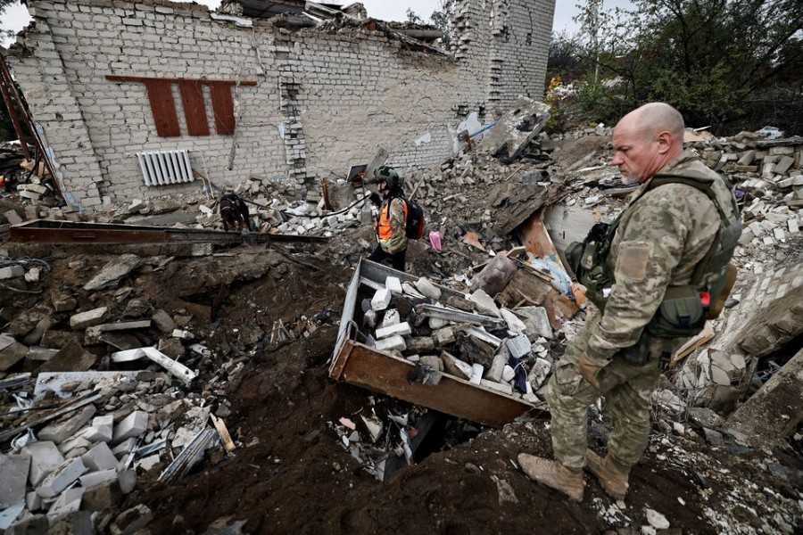 Firefighters and Ukrainian army soldiers search for bodies of people killed during a Russian attack, among the remains of a building beside a TV tower, in the recently liberated town of Izium, Kharkiv region, Ukraine September 28, 2022. REUTERS/ Zohra Bensemra