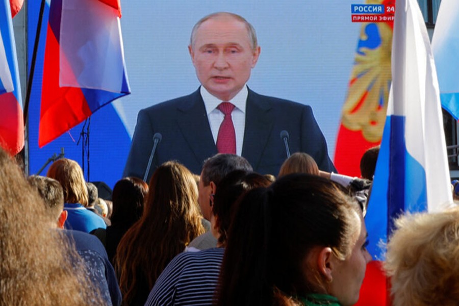 People gather near a screen showing Russian President Vladimir Putin during the broadcast of a ceremony to declare the annexation of the Russian-controlled territories of four Ukraine's Donetsk, Luhansk, Kherson and Zaporizhzhia regions, after holding what Russian authorities called referendums in the occupied areas of Ukraine that were condemned by Kyiv and governments worldwide, in Luhansk, Russian-controlled Ukraine on September 30, 2022 — Reuters photo