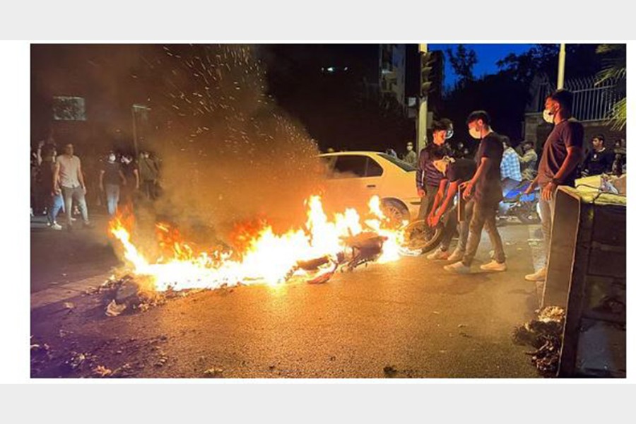 A police motorcycle burns during a protest over the death of Mahsa Amini, a woman who died after being arrested by the Islamic republic's "morality police", in Tehran, Iran September 19, 2022. WANA (West Asia News Agency) via REUTERS