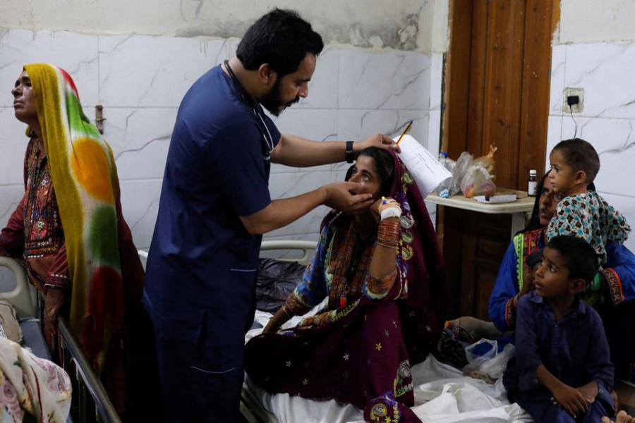 Naveed Ahmed, 30, a doctor, gives medical assistance to flood-affected girl Hameeda, 15, suffering from malaria at Sayed Abdullah Shah Institute of Medical Sciences in Sehwan, Pakistan September 29, 2022. REUTERS/Akhtar Soomro