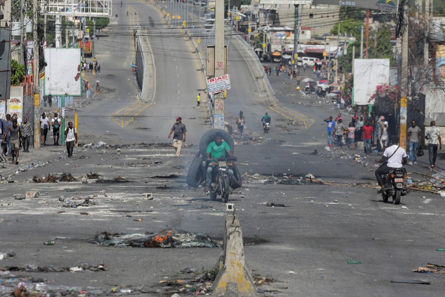 People pass through an empty street with remains of barricades during a nationwide strike against rising fuel prices, in Port-au-Prince, Haiti on September 26, 2022 — Reuters/Files