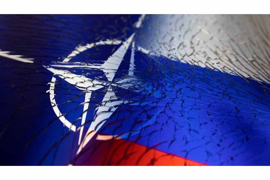 NATO and Russian flags are seen through broken glass this illustration taken April 13, 2022.REUTERS/Dado Ruvic/Illustration